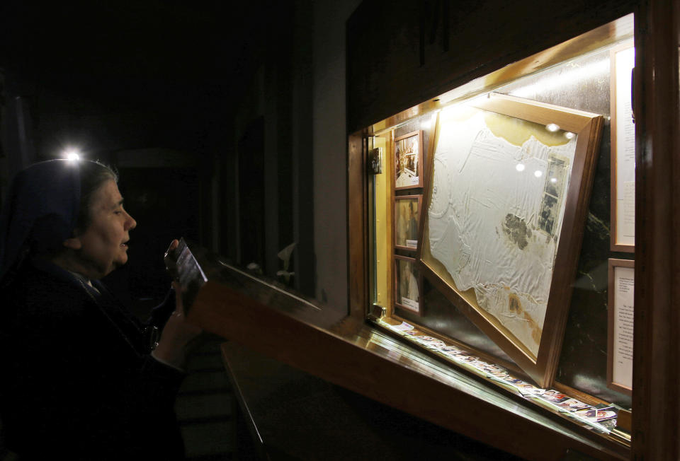 Sister Marisa from the Daughters of Charity closes the altar Thursday, April 10, 2014 where the bloodstained undershirt worn by Pope John Paul II during the assassination attempt on May, 13, 1981 is kept, in Rome. (AP Photo/Gregorio Borgia)