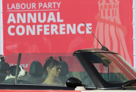 A woman drives past the Labour party Conference venue with a dog on the back seat of her car in Brighton, Britain, September 24, 2017. REUTERS/Toby Melville