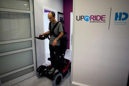 An employee stands on a wheelchair developed by Israeli company UPnRIDE Robotics, that enables paralysed people with limited function in their arms to stand upright, during a demonstration at their offices in Yoqneam, Israel September 6, 2016. REUTERS/Baz Ratner