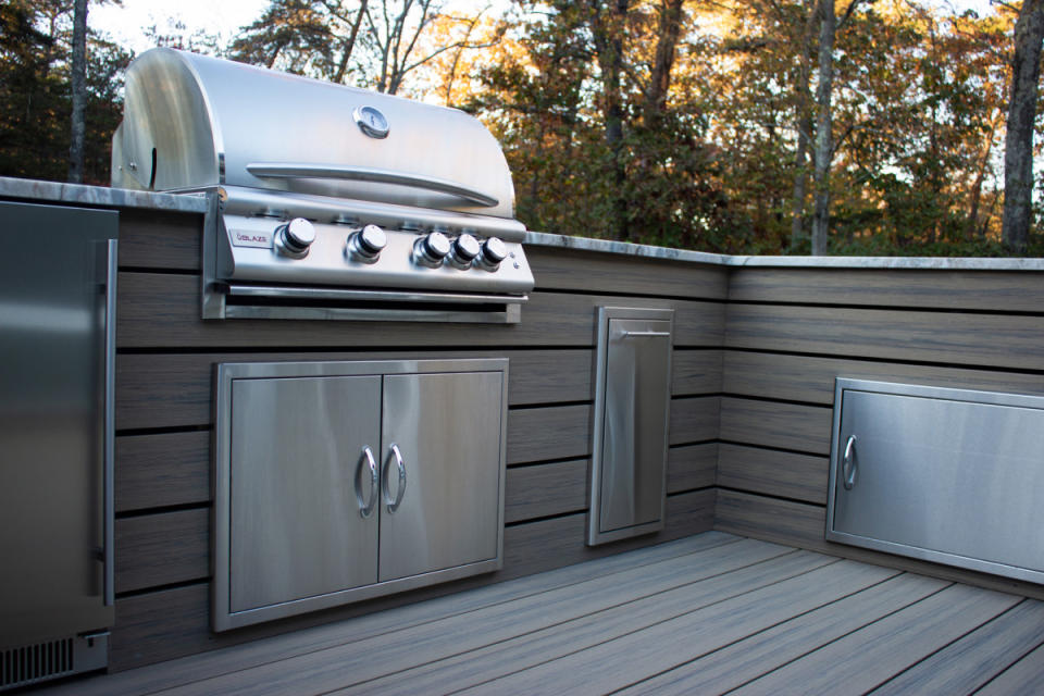 Low-maintenance composite decking makes an outdoor kitchen easier to clean.<p>Premier Outdoor Living</p>