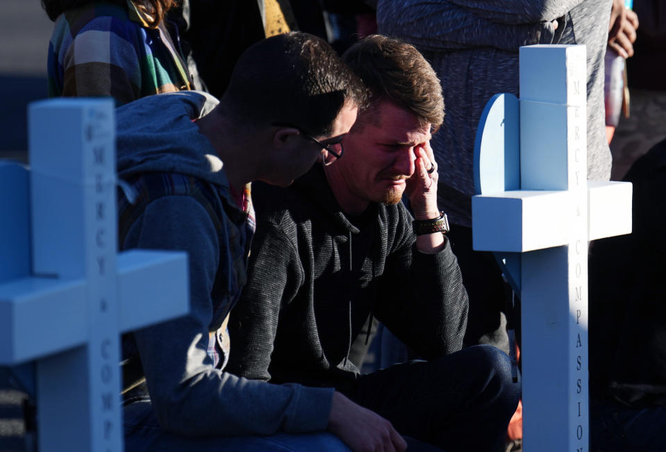 A man is comforted while crying at a makeshift tribute on a corner near the site of a weekend mass shooting at a gay bar, Monday, Nov. 21, 2022, in Colorado Springs, Colo. (AP Photo/Jack Dempsey)