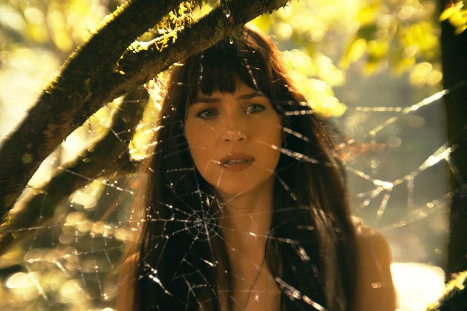 Dakota Johnson looking at a spider web