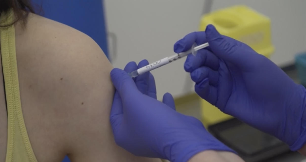 Screen grab taken from video issued by Britain's Oxford University, showing a person being injected as part of the first human trials in the UK to test a potential coronavirus vaccine, untaken by Oxford University in England, Thursday April 23, 2020.  Two volunteers have received the first vaccine trial against the COVID-19 Coronavirus on Thursday. (Oxford University Pool via AP)