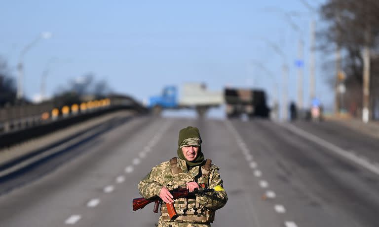 Un miembro del servicio ucraniano patrulla la carretera vacía en el lado oeste de la capital ucraniana de Kiev