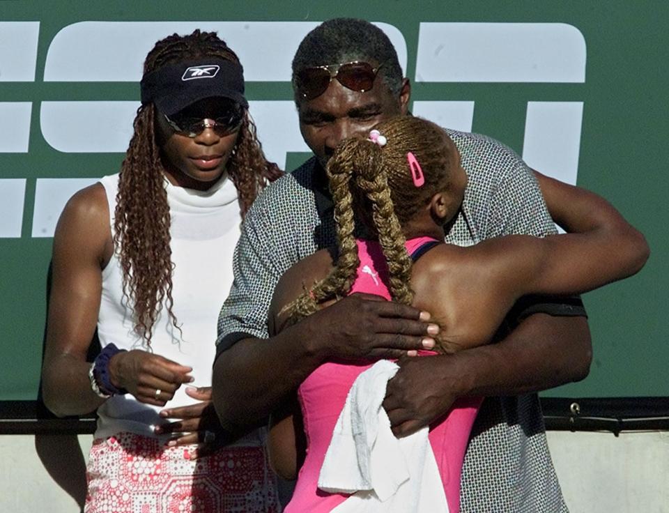 Serena Williams (right) hugs her father, Richard, as Venus looks on after a match at Indian Wells.