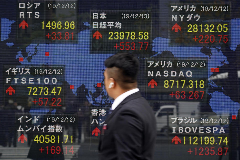 A man looks at an electronic stock board showing Japan's Nikkei 225 index and other country's index at a securities firm in Tokyo Friday, Dec. 13, 2019. Shares likewise jumped Friday in Asia following fresh all-time highs overnight on Wall Street spurred by optimism that the U.S. and China are close to reaching a deal to end their costly trade war. (AP Photo/Eugene Hoshiko)