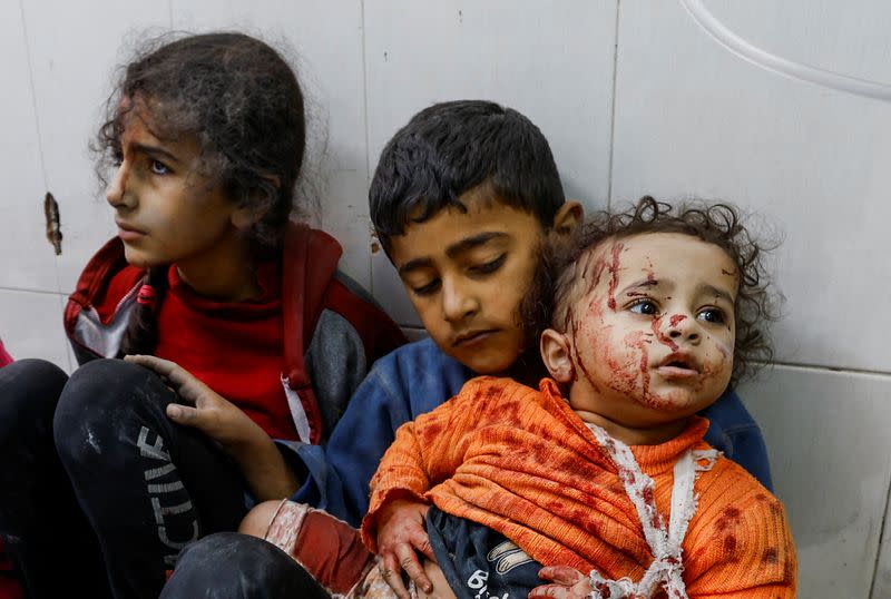 Wounded Palestinian children sit on the floor at Nasser hospital following Israeli strikes in Khan Younis