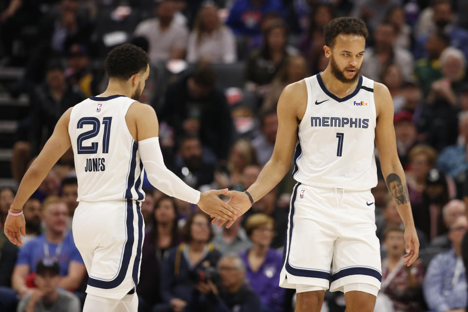 Memphis Grizzlies Tyus Jones, left, slaps palms with Kyle Anderson, right, as Anderson goes to the free-throw line during the first quarter of the team's NBA basketball game against the Sacramento Kings in Sacramento, Calif., Thursday, Feb. 20, 2020. (AP Photo/Rich Pedroncelli)