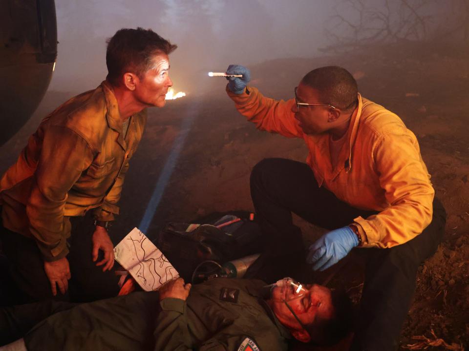 Hen (Aisha Hinds), right, a paramedic from Los Angeles- based "9-1-1," examines Austin-based firefighter Owen (Rob Lowe) after a helicopter crash during a wildfire in Monday's crossover on Fox's "9-1-1: Lone Star."
