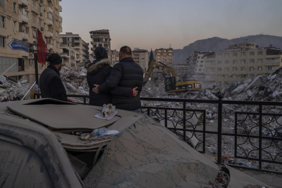 Men observe the site of collapsed buildings during the earthquake in Antakya, southeastern Turkey, Tuesday, Feb. 14, 2023. The death toll from the earthquakes of Feb. 6, that struck Turkey and northern Syria is still climbing. (AP Photo/Bernat Armangue)