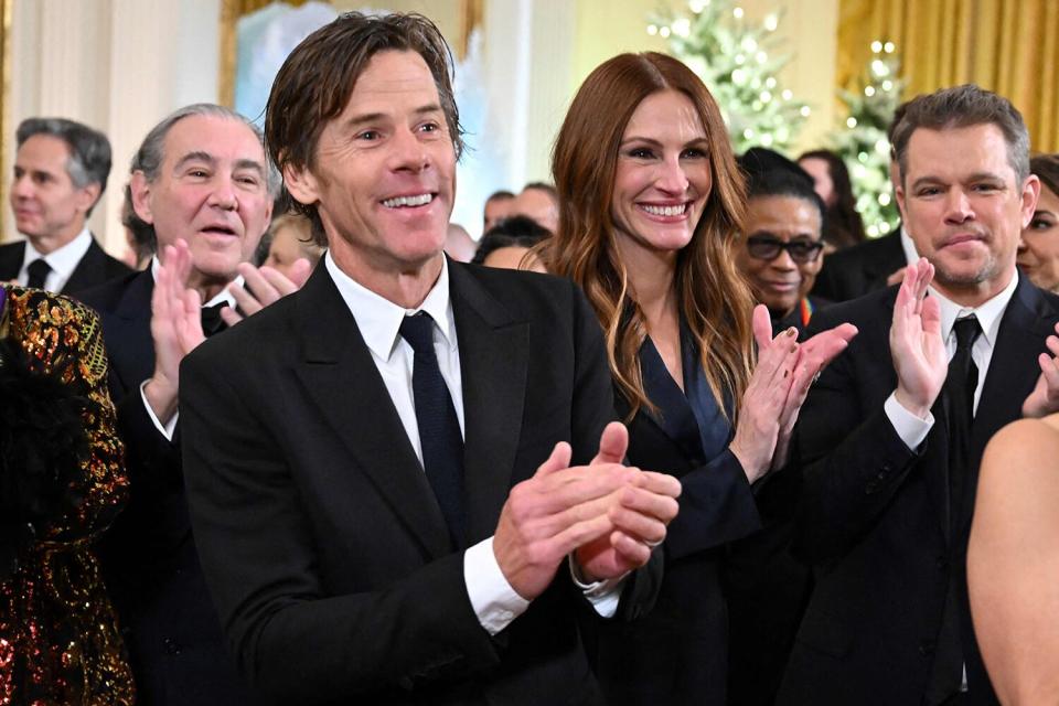 US actress Julia Roberts (2nd L), her husband Danny Moder and US actor Matt Damon applaud during a reception for the Kennedy Center Honorees in the East Room of the White House in Washington, DC, on December 4, 2022.