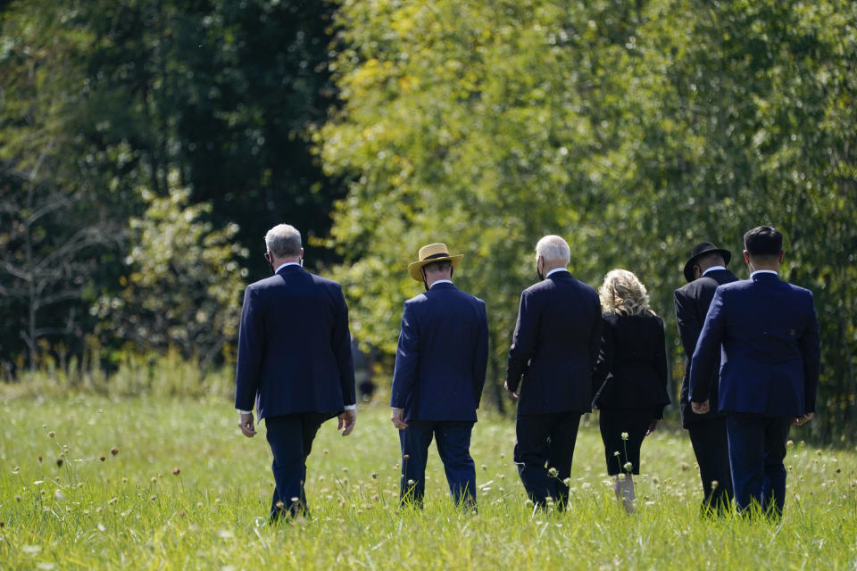 President Joe Biden and first lady Jill Biden walk with Gordon Felt, brother of Edward Porter Felt and President of Families for Flight 93, second from left, and Calvin Wilson the brother-in-law of First Officer LeRoy Homer, a passenger on Flight 93, second from right, to visit a boulder marking the impact site of Flight 93 at the Flight 93 National Memorial in Shanksville, Pa., Saturday, Sept. 11, 2021. The Bidens visited to commemorate the 20th anniversary of the Sept. 11, 2001, terrorist attacks. (AP Photo/Evan Vucci)