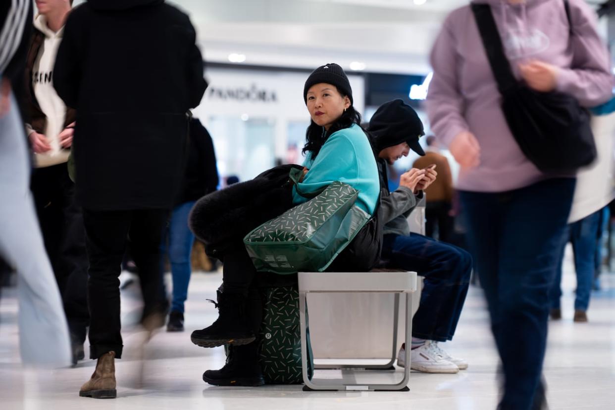 Shoppers take a break at Rideau Centre mall in Ottawa in December. The mall is closed Friday and Sunday. (Spencer Colby/The Canadian Press - image credit)