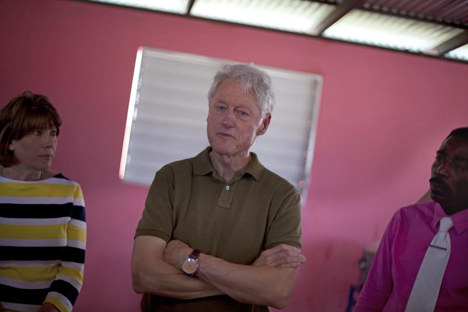 Former U.S. President and UN special envoy to Haiti Bill Clinton listens to members of the Union Des Apotres – Prodev School in Cite Soleil, Port-au-Prince, Haiti, Monday Feb. 17, 2014. Clinton is in Haiti to visit several projects that focus on agriculture and the environment, including the Union Des Apotres – Prodev solar-powered school that his private foundation has assisted and a training school for Haitian coffee farmers. (AP Photo/Dieu Nalio Chery)(AP Photo/Dieu Nalio Chery)