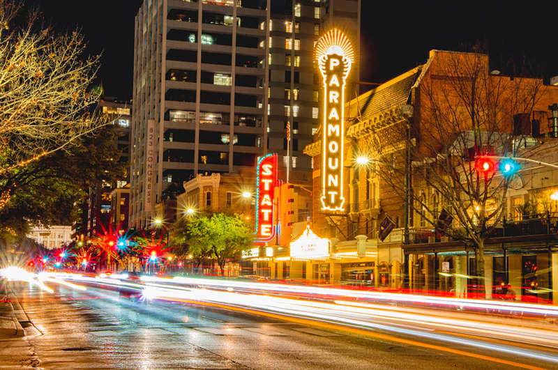 time exposure of traffic lights on congress avenue in downtown Austin infront of the Paramount and State theaters at night