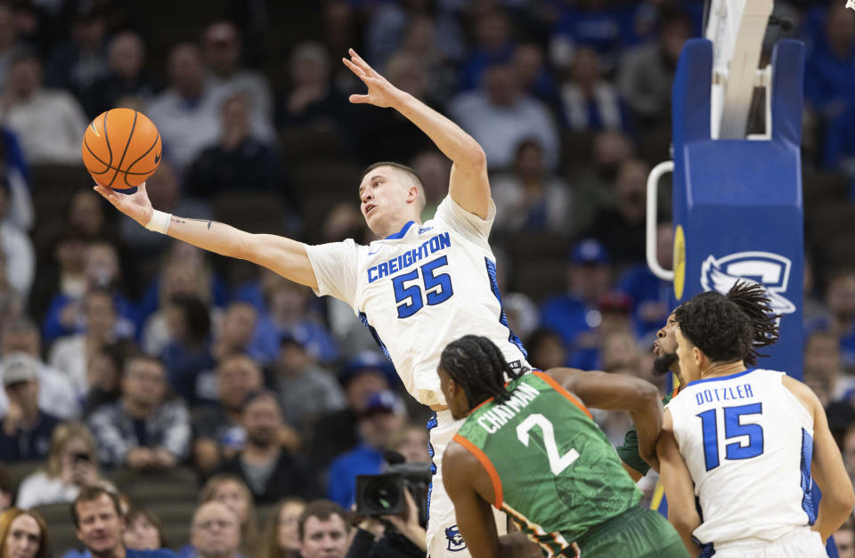 Creighton's Baylor Scheierman (55) reaches for a rebound against Florida A&M's Jordan Chatman (2) during the first half of an NCAA college basketball game on Tuesday, Nov. 7, 2023, in Omaha, Neb. (AP Photo/Rebecca S. Gratz)