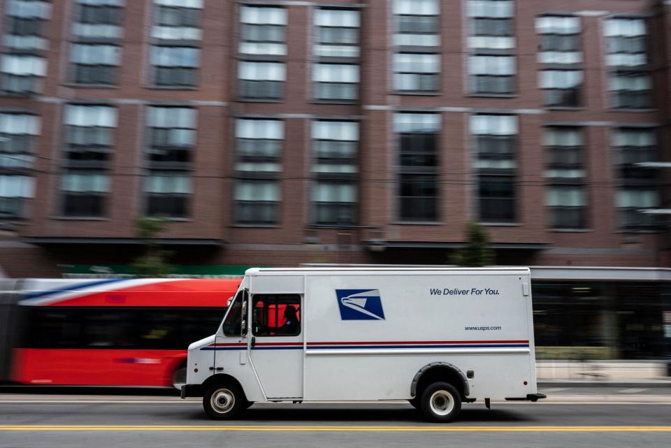 A postman drives a United States Postal service (USPS) mail delivery truck through Washington, DC on August 13, 2021.