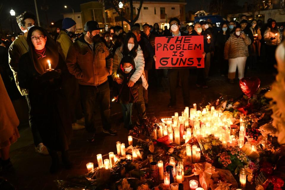 A group of mourners gathers in Monterey Park on Tuesday to take part in a vigil for the victims of a mass shooting