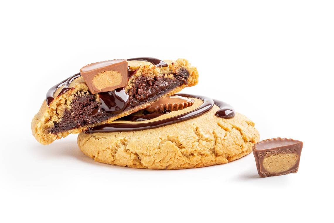 The “Reverse with Reese’s” cookie made by Dirty Dough is “fudge filling wrapped with a chocolate cookie then triple wrapped with a peanut butter cookie and topped with chocolate drizzle and crushed Reese’s.”