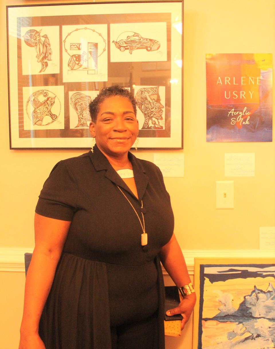 Arlene Usry poses with some of her work exhibited in the show.