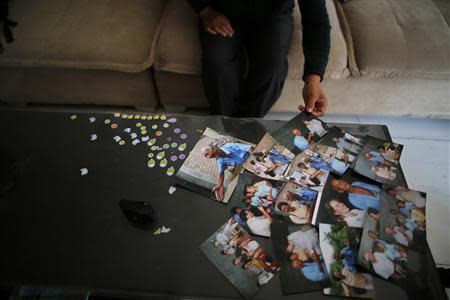 Liu Guolian displays pictures of her father Liu Qian, who was a forced labourer by Mitsui Mining to work in their mines in Fukuoka of Japan, during an interview with Reuters on the outskirts of Beijing, April 28, 2014. REUTERS/Petar Kujundzic