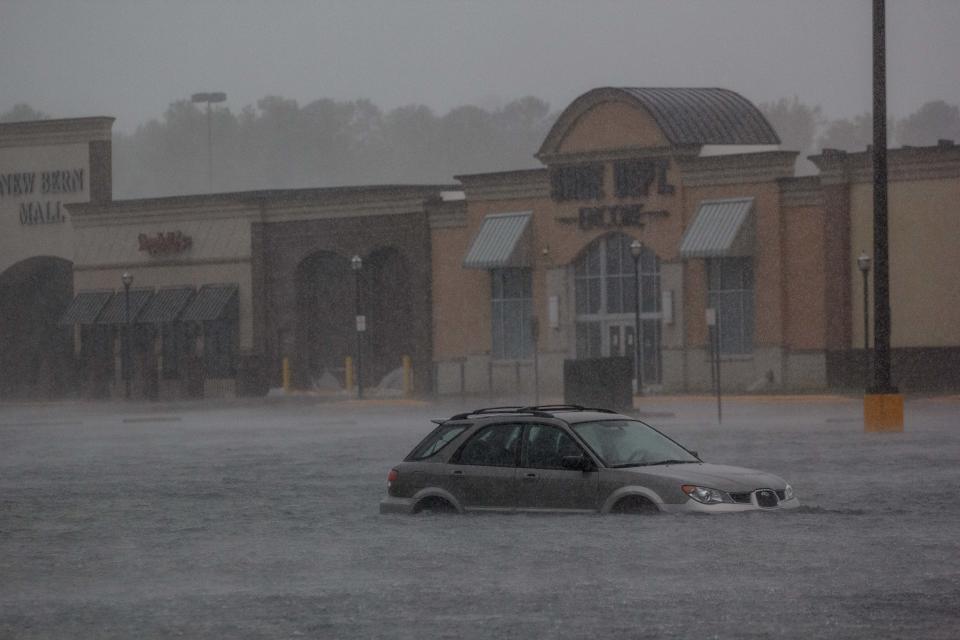 A car is seen in a flooded parking lot outside New Bern Mall in New Bern.