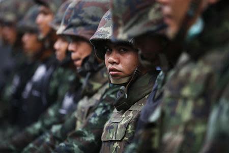 Soldiers stand guard as anti-government protesters gather at a Defence Ministry compound in north Bangkok, which is serving as a temporary office for Thai Prime Minister Yingluck Shinawatra February 19, 2014. REUTERS/Damir Sagolj