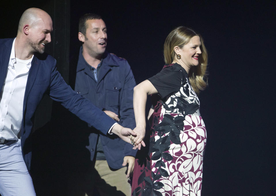 Actress Drew Barrymore (R) takes to the stage to accept the award for Female Star of the Year at the Big Screen Achievement Awards during CinemaCon, the official convention of the National Association of Theatre Owners, at Caesars Palace in Las Vegas, Nevada March 27, 2014. Actor Adam Sandler, winner of the Male Star of the Year award, looks on. REUTERS/Steve Marcus (UNITED STATES)