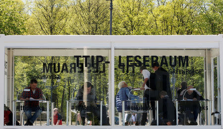 People read copies of the leaked TTIP negotiations inside a public reading room by the environmental campaign group Greenpeace in front of the Brandenburg Gate in Berlin, Germany, May 2, 2016. REUTERS/Fabrizio Bensch