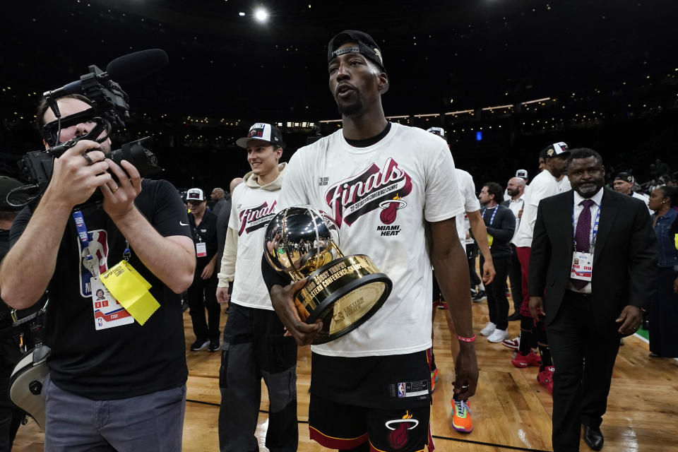 Miami Heat center Bam Adebayo walks off the court while holding the Bob Cousy Trophy after winning Game 7 of the NBA basketball Eastern Conference finals against the Boston Celtics Monday, May 29, 2023, in Boston. (AP Photo/Charles Krupa )
