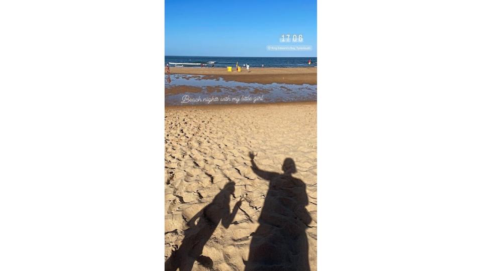 shadows of mother and daughter at beach