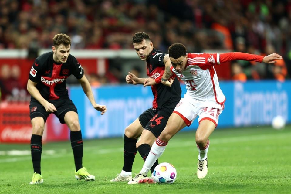 LEVERKUSEN, GERMANY: Granit Xhaka of Bayer Leverkusen battles for possession with Jamal Musiala of Bayern Munich during the Bundesliga match between Bayer 04 Leverkusen and FC Bayern München at BayArena on February 10, 2024. (Photo by Leon Kuegeler/Getty Images)