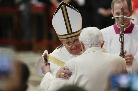 Pope Francis (L) greets Pope Emeritus Benedict XVI as he arrives to attend a consistory ceremony in Saint Peter's Basilica at the Vatican February 22, 2014. REUTERS/Max Rossi