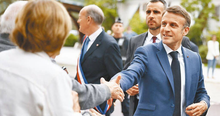 法國總統馬克宏6月30日抵達投票站，與支持者握手。（圖／路透）