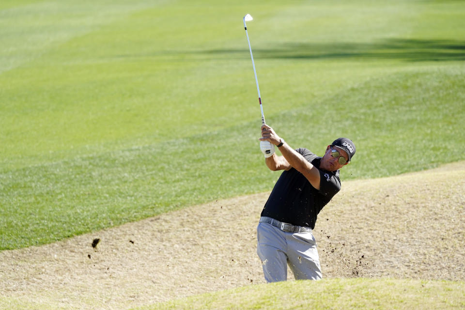 Phil Mickelson hits from a bunker off the 18th fairway during the first round of The American Express golf tournament on the Nicklaus Tournament Course at PGA West Thursday, Jan. 21, 2021, in La Quinta, Calif. (AP Photo/Marcio Jose Sanchez)