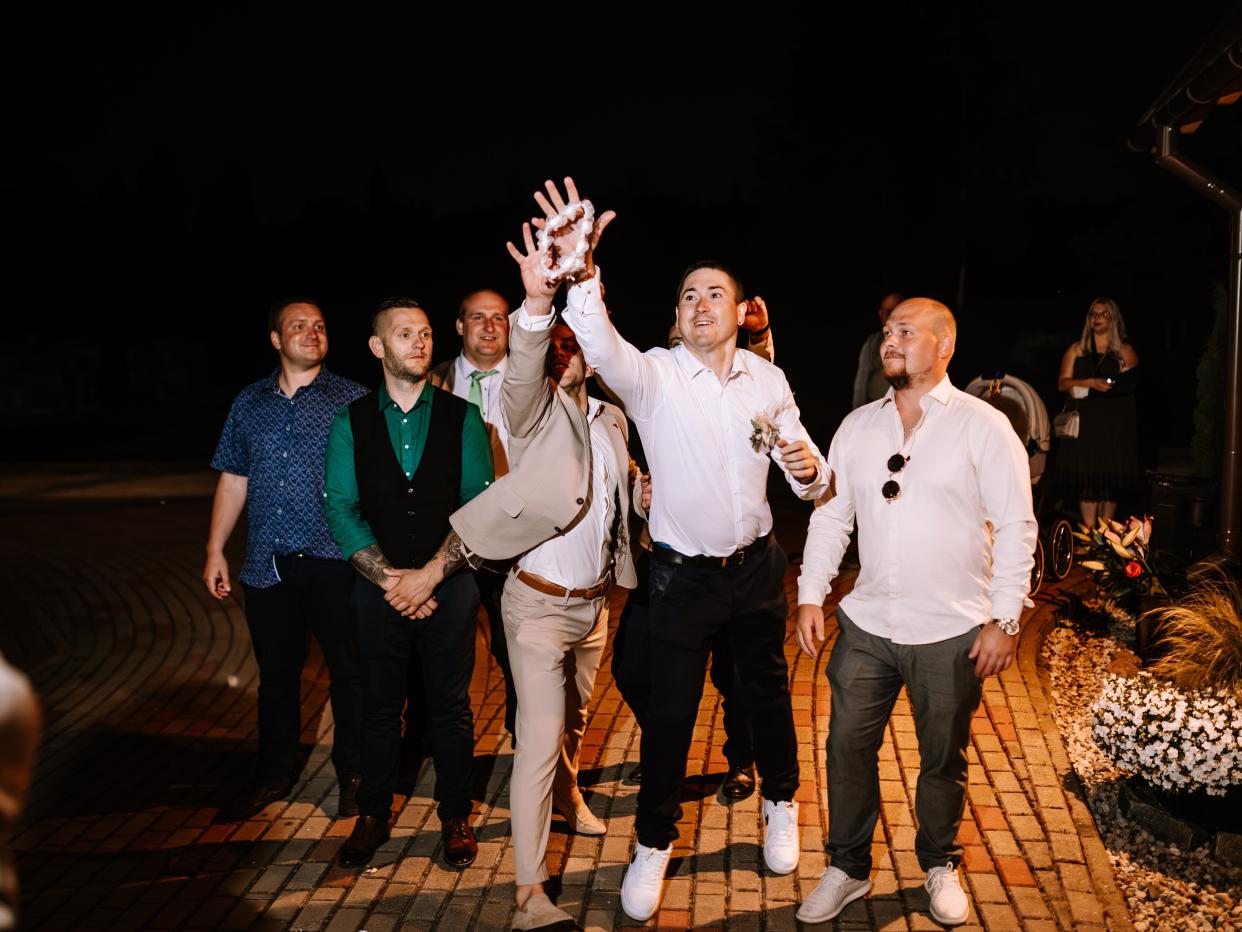 Men trying to catch the bride's garter.
