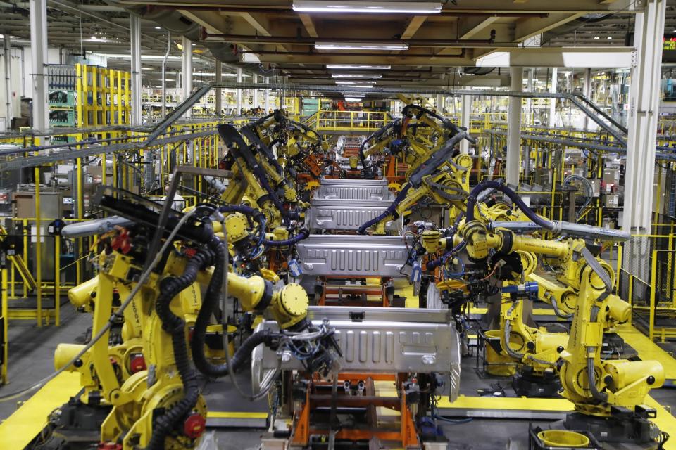 FILE- In this Sept. 27, 2018, file photo robots weld the bed of a Ford F Series trucks on the assembly line at the Ford Rouge assembly plant in Dearborn, Mich. Ford Motor Co. is recalling nearly 262,000 heavy-duty pickup trucks in the U.S. and Canada because the tailgates can open unexpectedly. The recall covers F-250, F-350 and F-450 trucks from the 2017 through 2019 model years. All the trucks have electric tailgate latch release switches in the tailgate handle. (AP Photo/Carlos Osorio, File)