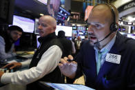 Trader Michael Milano, right, works on the floor of the New York Stock Exchange, Thursday, July 18, 2019. U.S. stocks moved lower in early trading on Wall Street Thursday after Netflix reported a slump in new subscribers and dragged down communications companies. (AP Photo/Richard Drew)