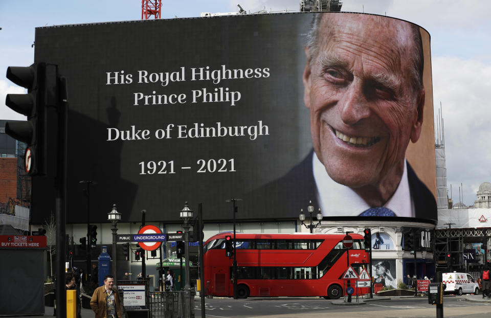 FILE - In this file photo dated Friday, April 9, 2021, a tribute to Britain's Prince Philip is projected onto a large screen at Piccadilly Circus in central London. Buckingham Palace officials say Prince Philip, the husband of Queen Elizabeth II, has died, aged 99. Prince Philip who died Friday April 9, 2021, aged 99, lived through a tumultuous century of war and upheavals, but he helped forge a period of stability for the British monarchy under his wife, Queen Elizabeth II. (AP Photo/Matt Dunham, FILE)