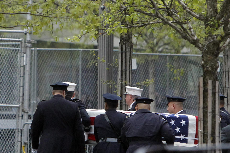 Officials acting as pallbearers carry a casket with the unidentified remains of victims of the Sept. 11, 2001 attacks as they are returned to the World Trade Center site, Saturday, May 10, 2014, in New York. The remains were moved from the Office of the Chief Medical Examiner on Manhattan's East Side at dawn Saturday to an underground repository in the same building as the National September 11 Memorial Museum.