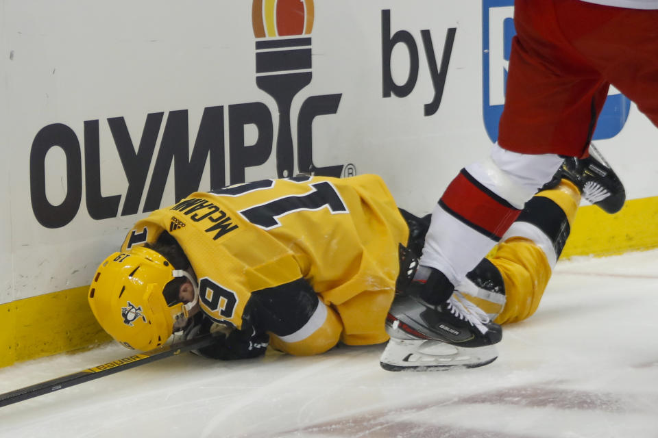 Pittsburgh Penguins' Jared McCann (19) lays on the ice after being checked into the boards by Carolina Hurricanes' Vincent Trocheck during the second period of an NHL hockey game, Sunday, March 8, 2020, in Pittsburgh. McCann left the game and Trocheck was penalized for boarding. (AP Photo/Keith Srakocic)