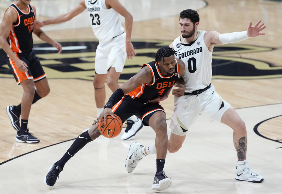 Oregon State guard Dexter Akanno (4) drives to the basket as Colorado guard Luke O'Brien (0) defends in the first half of an NCAA college basketball game Saturday, Jan. 20, 2024, in Boulder, Colo. (AP Photo/David Zalubowski)