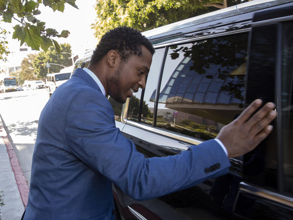 Rapper Marcus Gray avoids talking to the media as he rushes into a waiting SUV, outside the federal courthouse in Los Angeles, Thursday, Aug. 1, 2019. A jury has decided that Katy Perry, her collaborators and her record label must pay more than $2.78 million because the pop star's 2013 hit "Dark Horse" copied a Christian rap song. It was an underdog victory for relatively obscure artist Gray, whose 5-year-old lawsuit survived constant court challenges. Perry's attorney said they plan to vigorously fight the decision. (AP Photo/Damian Dovarganes)