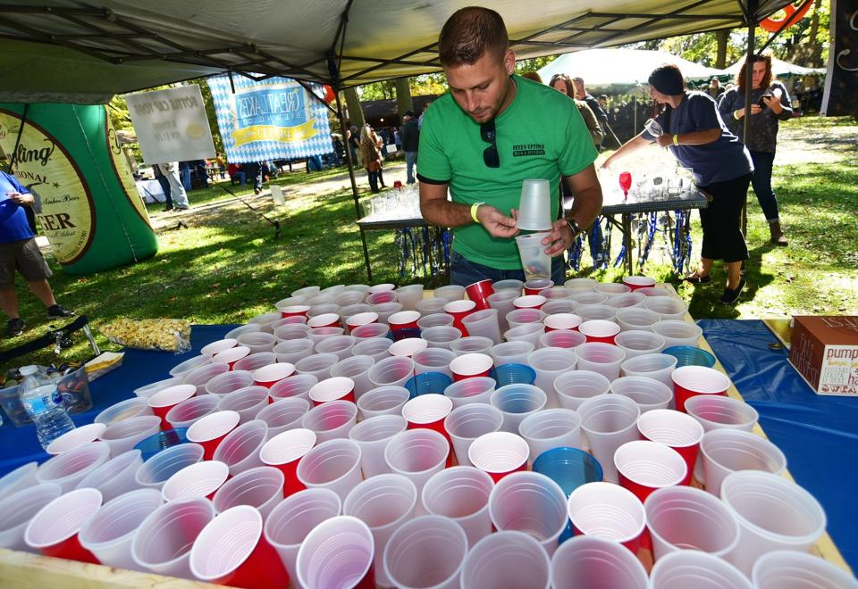 Robert Rusnic of Beaver Falls prepares the bottle cap toss game for the next contestant during the 10th annual Oktoberfest Beer Festival in Ellwood City's Ewing Park. Rusnic´s family owns Pete´s Uptown Bar & Beverage. [Lucy Schaly/For ECL]