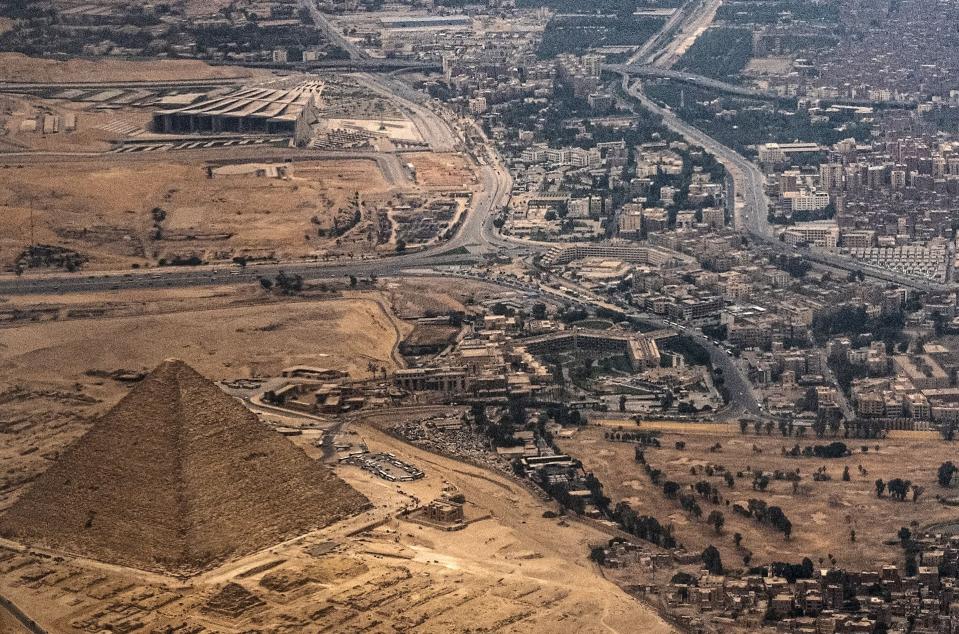 This picture taken on April 22, 2022 shows an aerial view of  the Great Pyramid of Khufu and the under-construction Grand Egyptian Museum, expected to be inaugurated later this year, in Cairo, Egypt. 