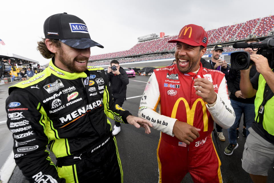 Bubba Wallace, front right, is congratulated by Ryan Blaney, left, after Wallace was pronounced the winner while on pit row during a rain delay in a NASCAR Cup series auto race Monday, Oct. 4, 2021, in Talladega, Ala. (AP Photo/John Amis)