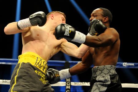 Jul 12, 2014; Las Vegas, NV, USA; Jason Quigley (green trunks) and Howard Reece (black trunks) exchange blows during a middleweight fight at MGM Grand. Mandatory Credit: Stephen R. Sylvanie-USA TODAY Sports