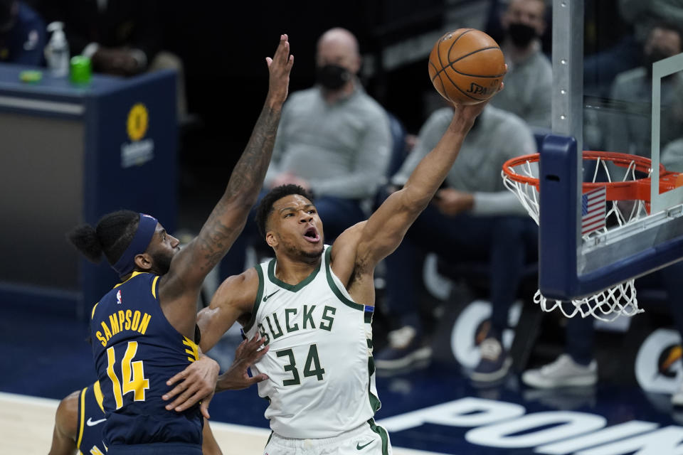 Milwaukee Bucks' Giannis Antetokounmpo (34) dunks against Indiana Pacers' JaKarr Sampson (14) during the second half of an NBA basketball game Thursday, May 13, 2021, in Indianapolis. (AP Photo/Darron Cummings)