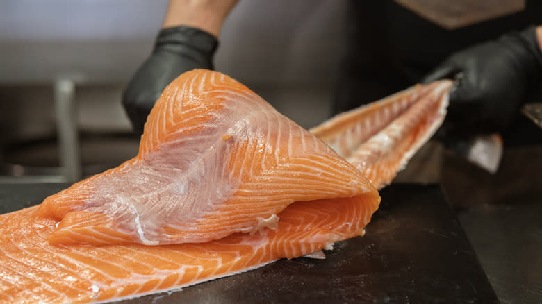 chef peeling skin off fish