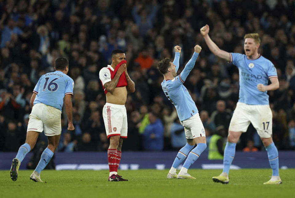 Manchester City's John Stones, second right, celebrates scoring their side's second goal of the game, as Arsenal's Gabriel Jesus stands dejected the English Premier League soccer match between Manchester City and Arsenal at Etihad stadium in Manchester, England, Wednesday, April 26, 2023. (Martin Rickett/PA via AP)